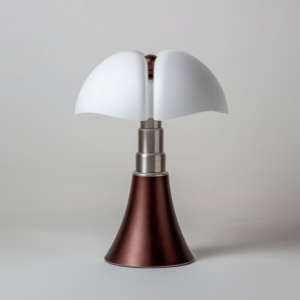 La lampe Pipistrello, crée par la talentueuse Gae Aulenti pour Martinelli Luce, est depuis longtemps une icône du design. Ce luminaire sculptural, immédiatement reconnaissable, s'illustre par son originalité et son élégance intemporelle. Aujourd'hui, la marque italienne dévoile une nouvelle version en finition bronze, ajoutant une dimension encore plus sophistiquée à ce classique indémodable.