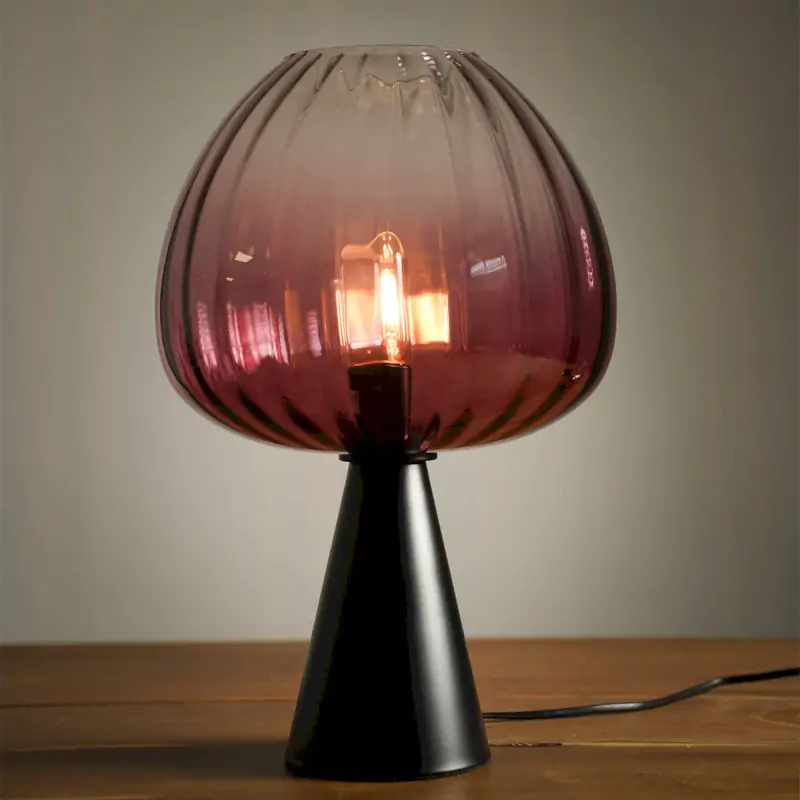 Lampe à poser design en verre fumé rose de 44 cm avec base noire. Un luminaire élégant diffusant une lumière douce et chaleureuse.