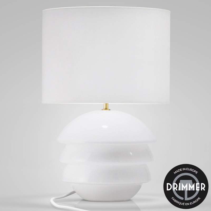 Lampe à poser design en céramique blanche avec abat-jour en tissu. Un luminaire décoratif élégant diffusant une lumière douce pour un éclairage intérieur chaleureux.