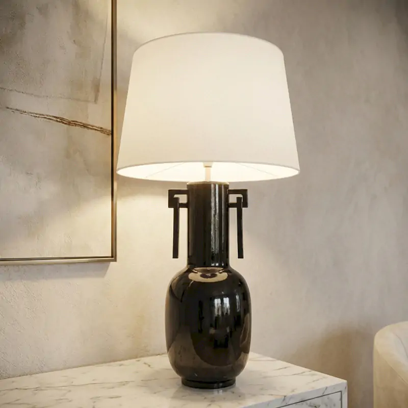 Lampe à poser design avec pied en céramique noire brillante et abat-jour blanc. Élégante et intemporelle pour salon ou chambre.