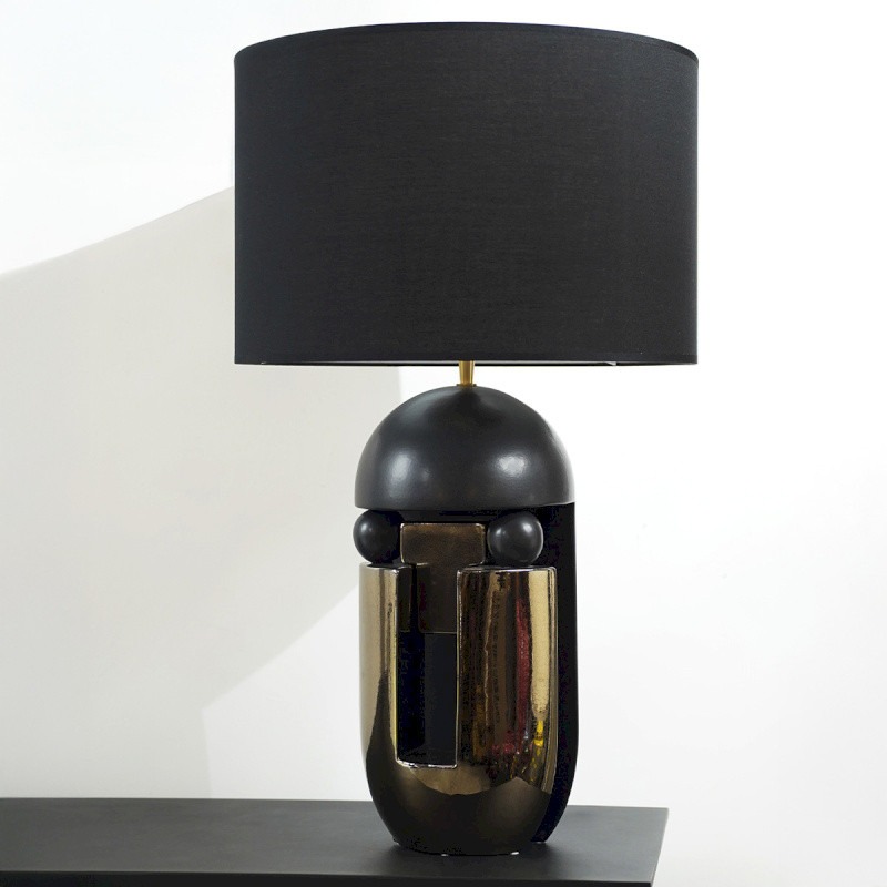 Lampe à poser design noir avec inserts bronze et abat-jour noir. Une pièce sculpturale élégante pour une décoration contemporaine sophistiquée.