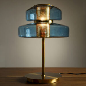 Lampe à poser design en verre bleu et métal doré avec diffuseur central perforé. Un luminaire élégant et chaleureux pour salon ou chambre.