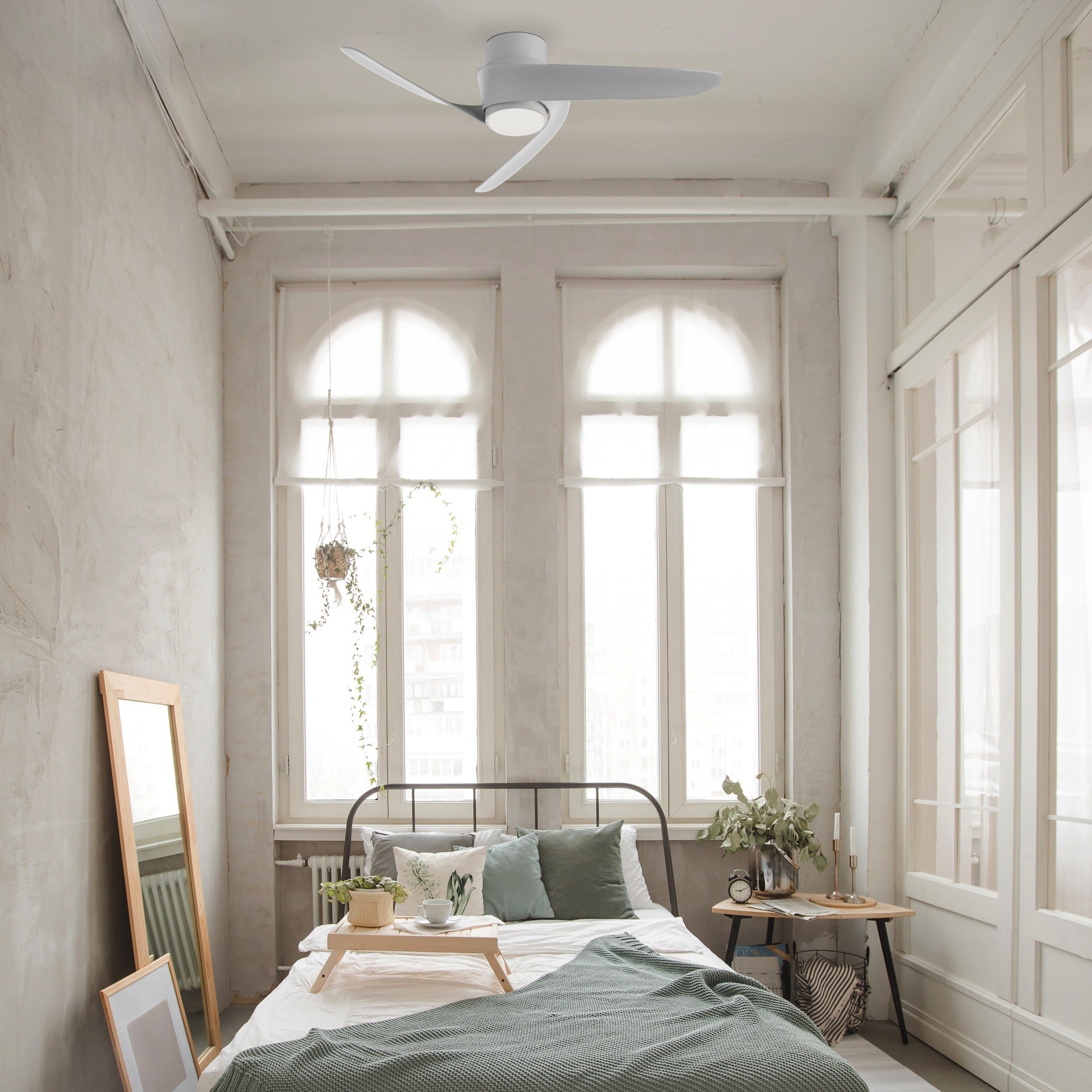 Ventilateur de plafond compact et silencieux blanc installé dans une chambre à coucher lumineuse