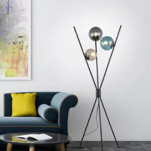 Lampadaire trepied en verre colore allume a cote d'un canape bleu dans un salon.