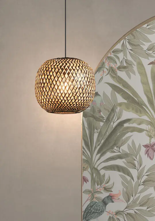 Suspension boule bambou tresse allumee devant un papier peint a motifs botaniques.