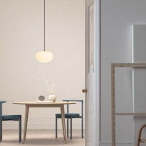 Suspension galet verre opalin allumee au-dessus d'une table en bois pres de Royan.