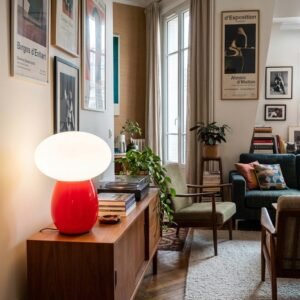 Lampe champignon rouge et opaline allumee sur un meuble clair pres de Royan.