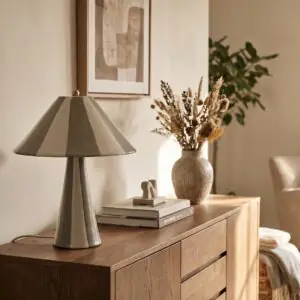 Lampe en ceramique a rayures allumee sur une console en bois clair pres de Royan.