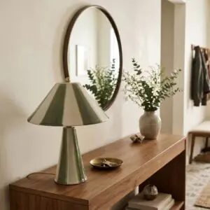 Lampe en ceramique a rayures vertes allumee sur une console en bois dans une entree pres de Royan.