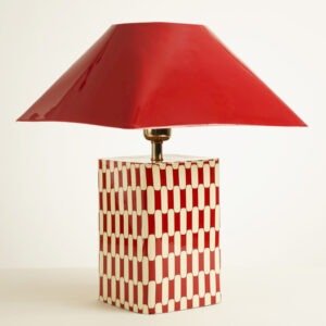 Grande lampe a poser rectangulaire en metal rouge avec socle a motif et chapeau pyramidal.